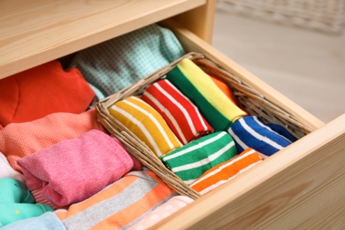 Many different colorful socks in open drawer, closeup