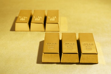 Photo of Many shiny gold bars on color background