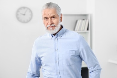 Portrait of handsome senior man in office