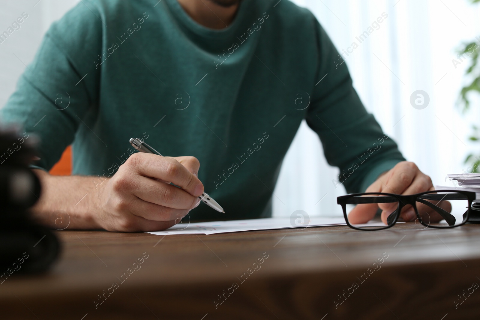 Photo of Businessman working with documents at office table, closeup