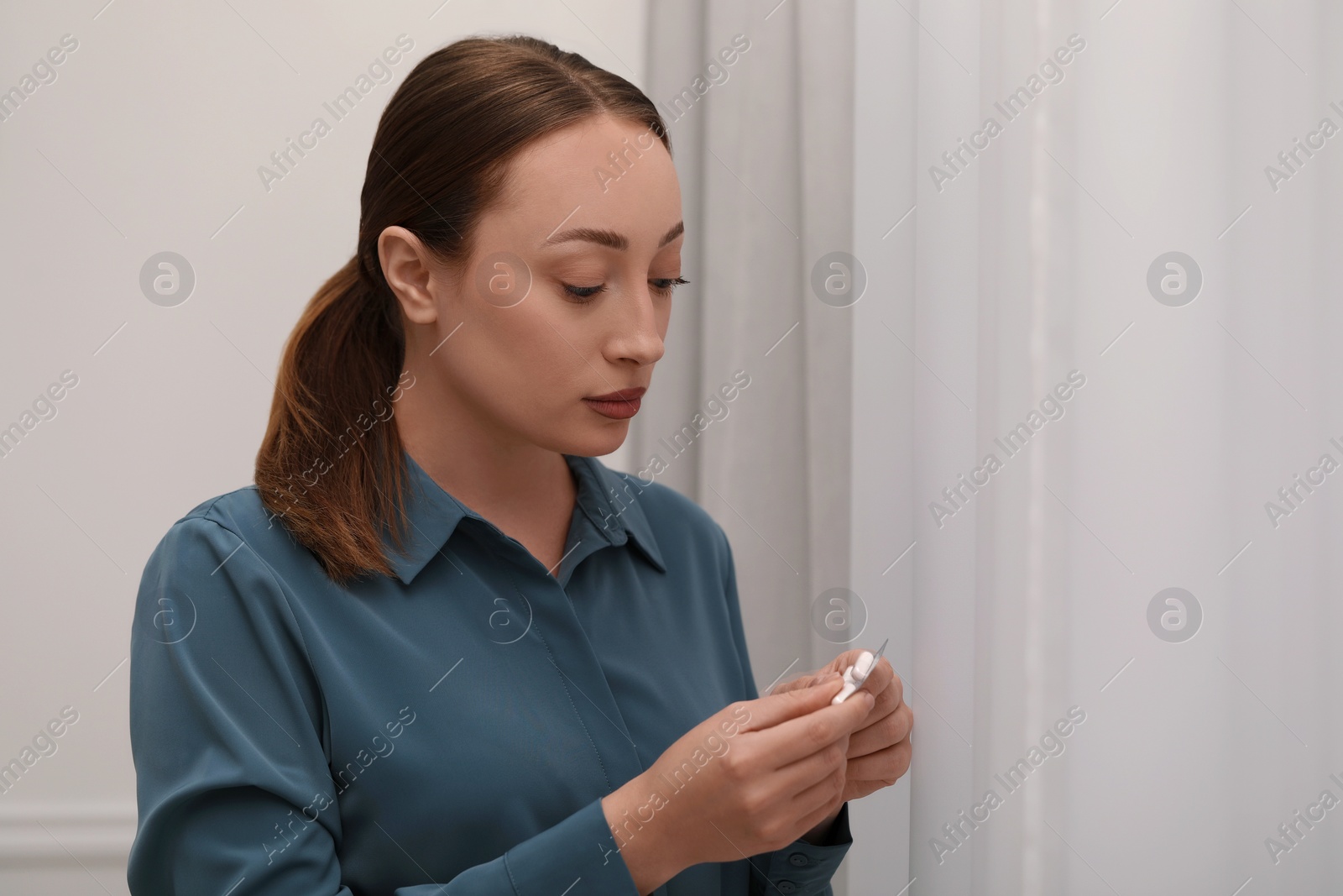 Photo of Woman taking antidepressant pill out from blister indoors. Space for text