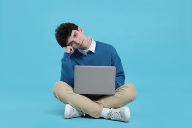 Photo of Portrait of student with laptop on light blue background