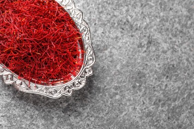 Dried saffron on grey table, top view. Space for text