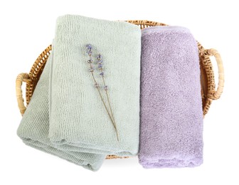 Basket with different soft towels and lavender flowers isolated on white, top view