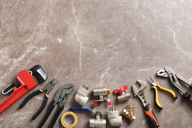 Flat lay composition with plumber's tools and space for text on grunge background