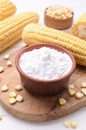 Bowl with corn starch and kernels on white table