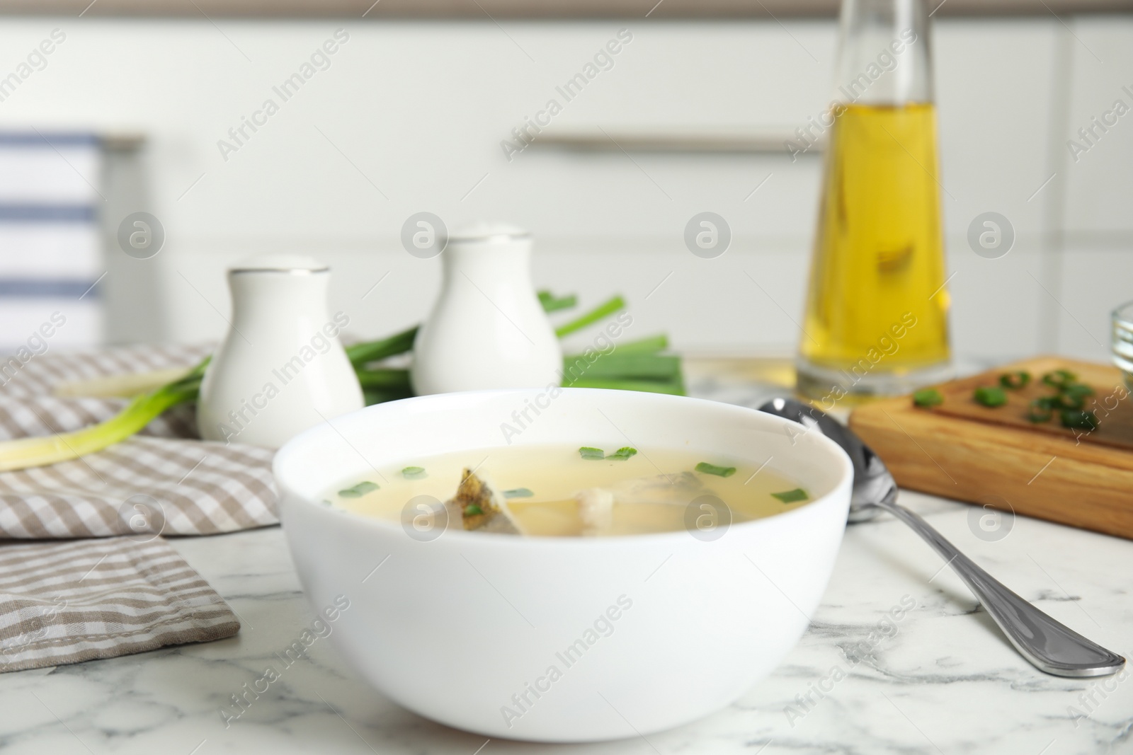 Photo of Delicious fish soup served on marble table