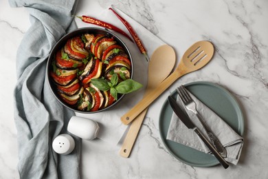 Photo of Delicious ratatouille, chili peppers and cutlery on white marble table, flat lay