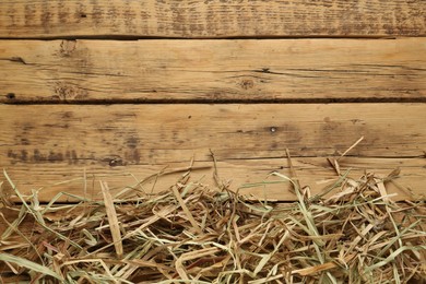 Dried hay on wooden background, flat lay. Space for text