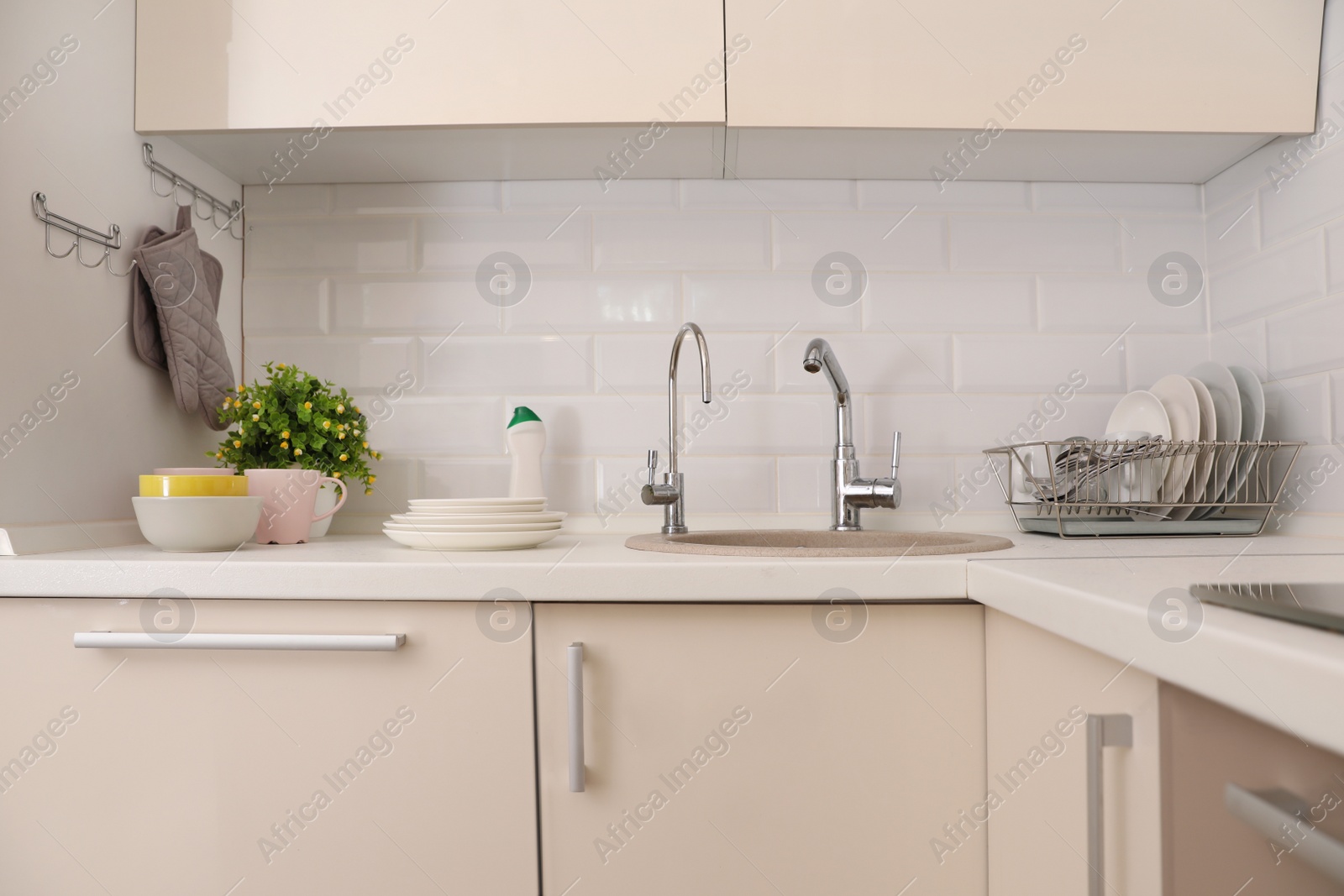 Photo of Clean dishes on counter near kitchen sink indoors