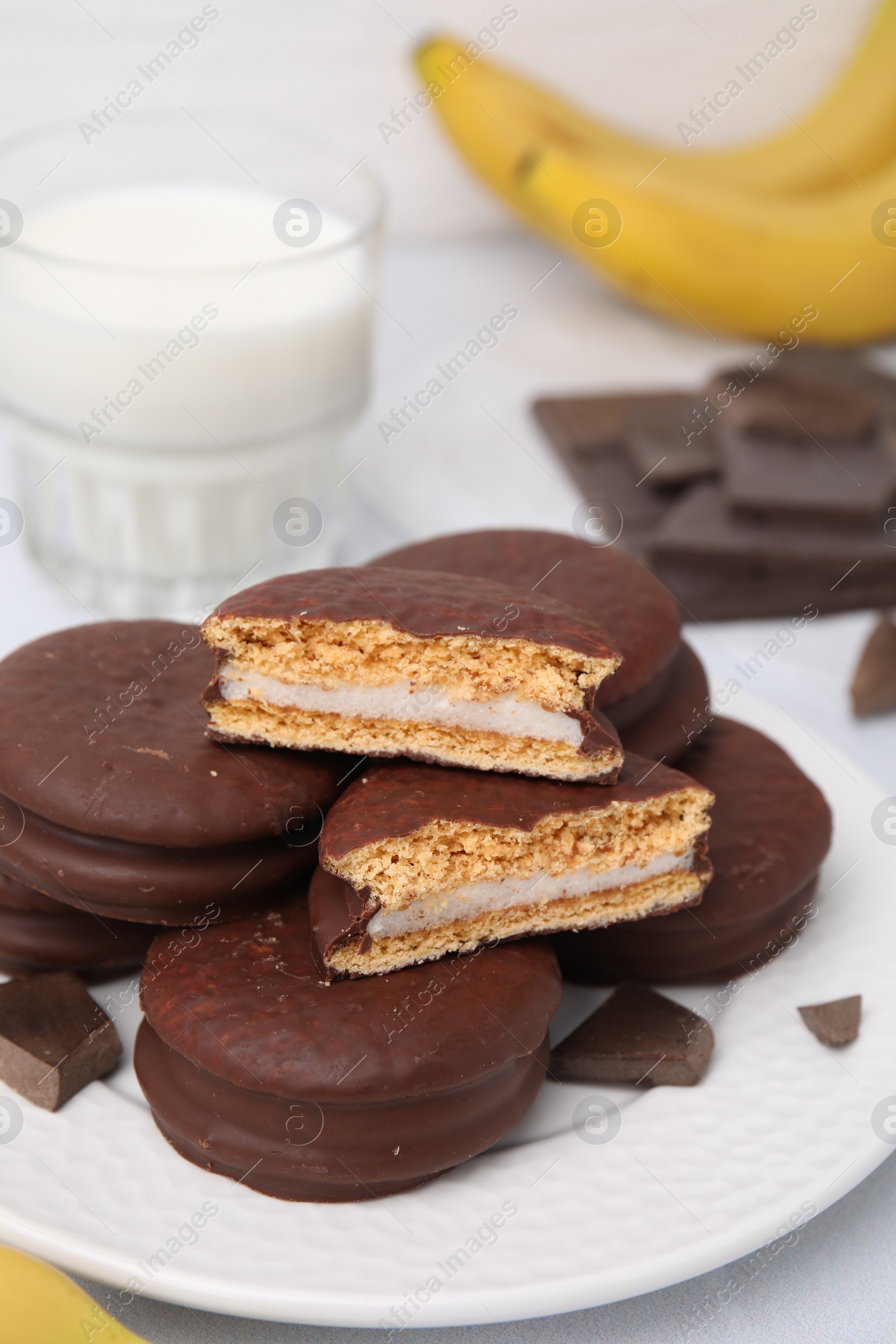 Photo of Tasty banana choco pies and pieces of chocolate on table, closeup