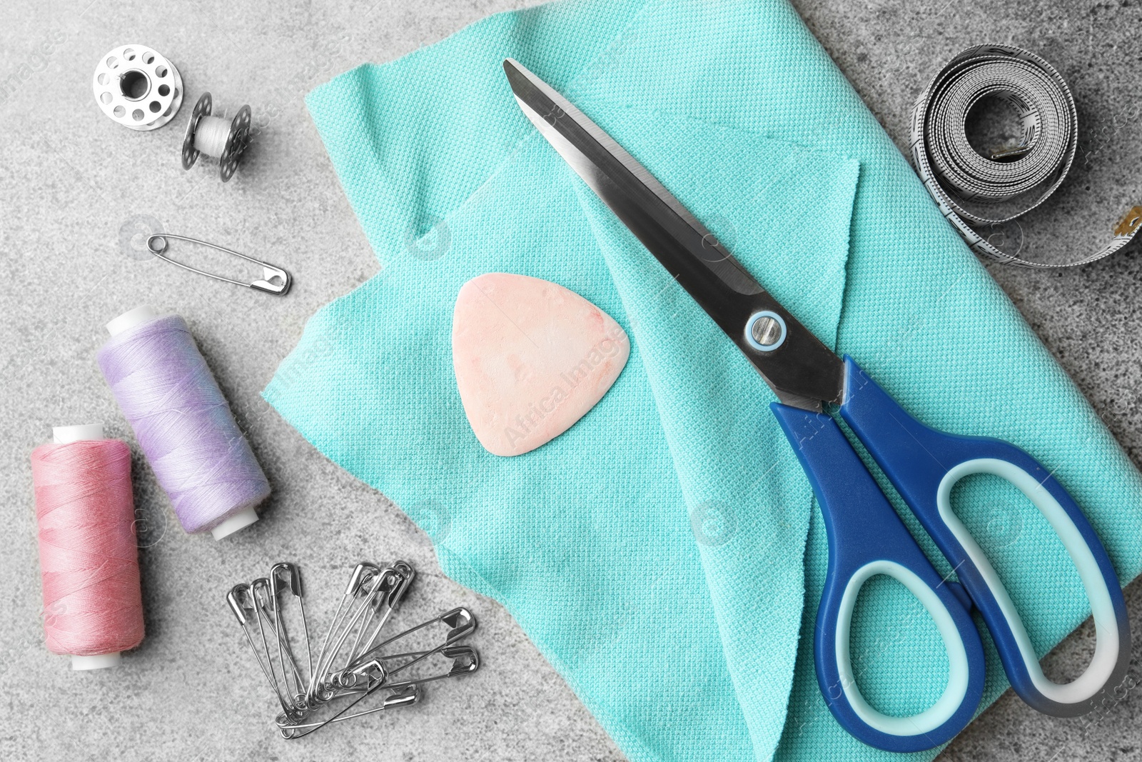 Photo of Flat lay composition with scissors, spools of threads and sewing tools on light grey background