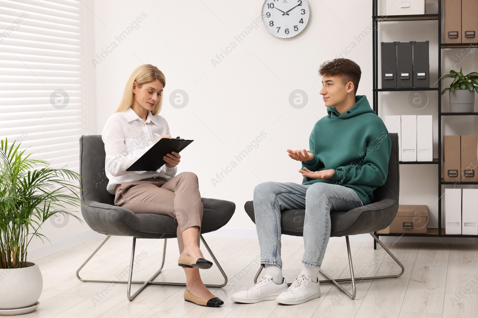 Photo of Psychologist working with teenage boy in office