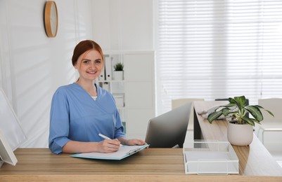 Receptionist with clipboard at countertop in hospital, space for text