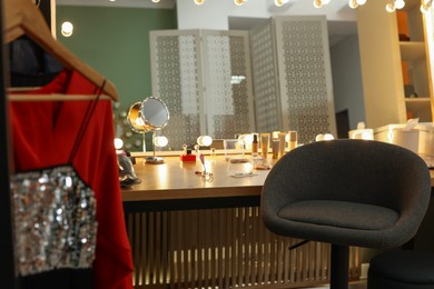 Makeup room. Chair near dressing table with different beauty products