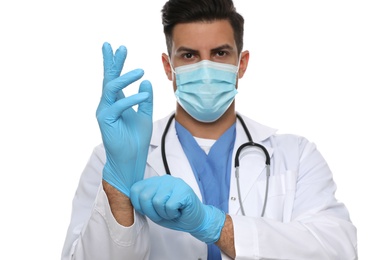 Photo of Doctor in protective mask putting on medical gloves against white background