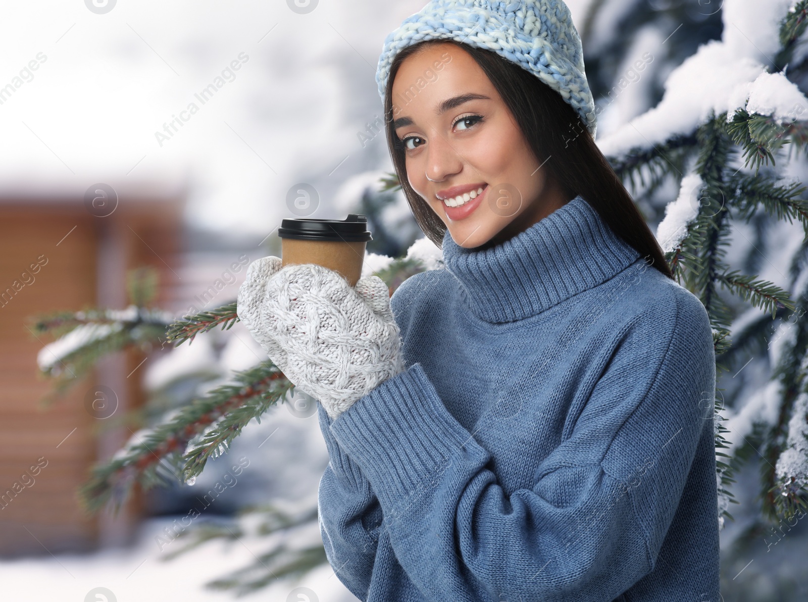 Image of Happy beautiful woman with mulled wine outdoors on snowy day 