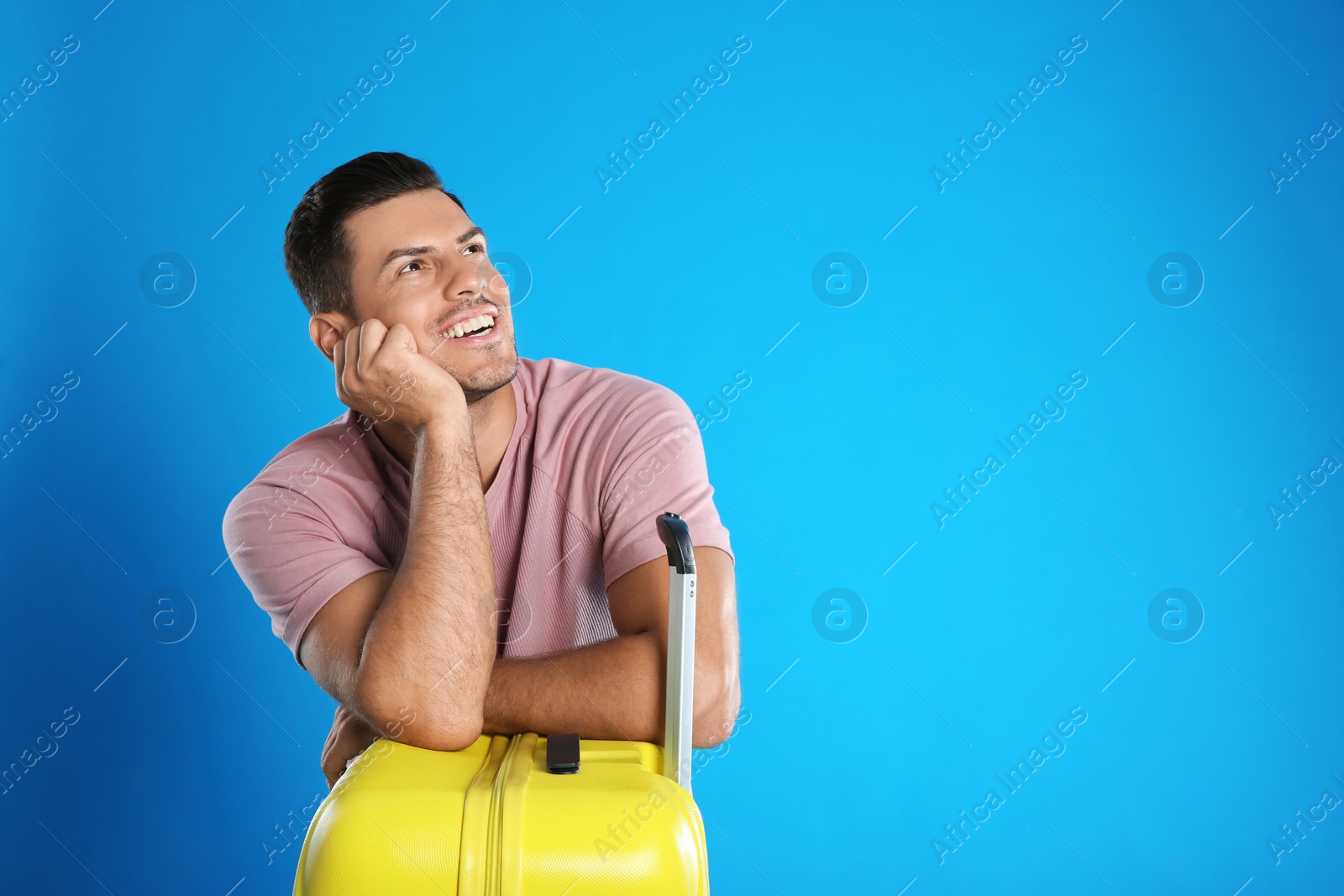 Photo of Man with suitcase for summer trip on blue background. Vacation travel