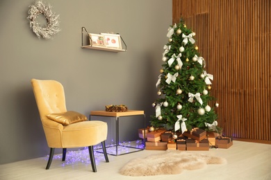 Photo of Room interior with beautiful Christmas tree and gifts