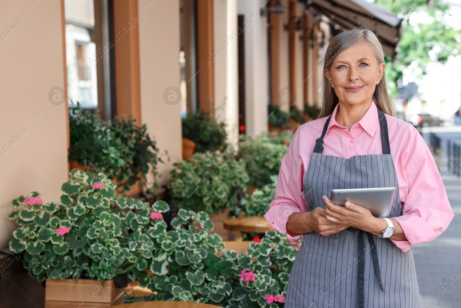 Photo of Happy business owner with tablet near her cafe outdoors, space for text