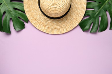 Photo of Stylish straw hat and tropical leaves on lilac background, flat lay. Space for text