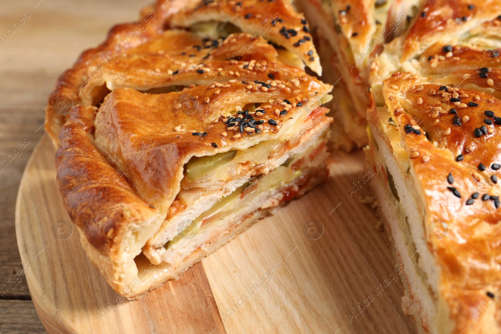 Photo of Cut delicious homemade pie on wooden table, closeup