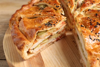 Photo of Cut delicious homemade pie on wooden table, closeup