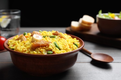Photo of Delicious pilaf with chicken meat on wooden table