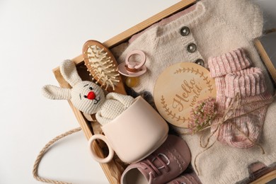 Photo of Box with baby clothes, shoes and accessories on light background, top view