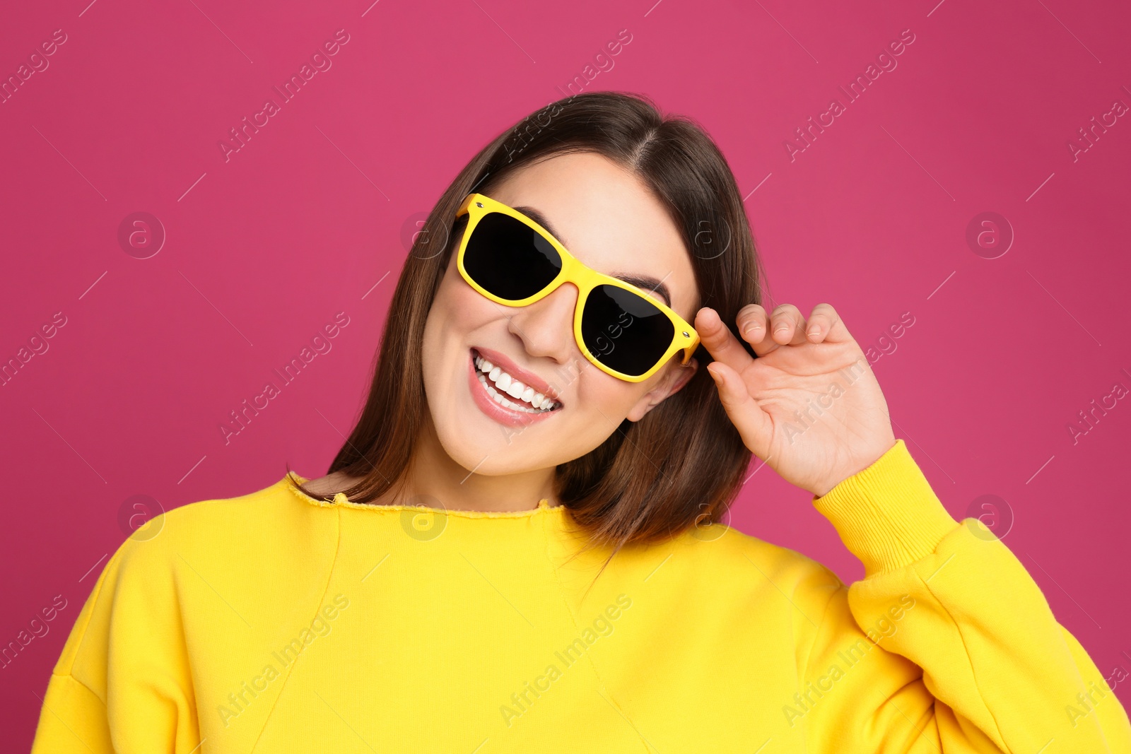 Photo of Young woman with sunglasses on pink background