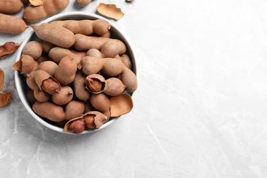 Photo of Delicious ripe tamarinds on light table, flat lay. Space for text