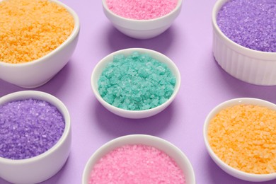 Photo of Different types of aromatic sea salt on purple background