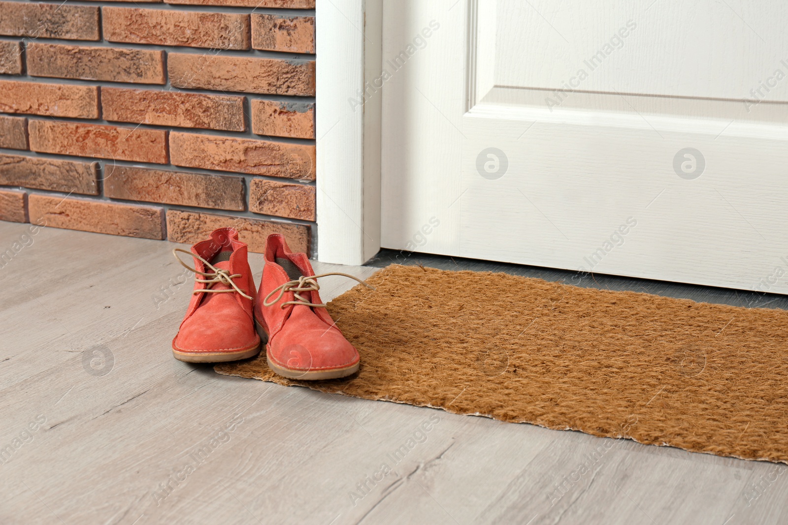 Photo of New clean mat with shoes near entrance door