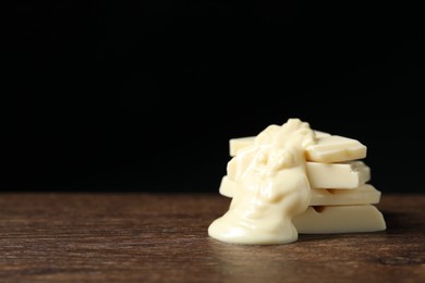 Photo of Pieces of white chocolate with tasty paste on wooden table, closeup. Space for text
