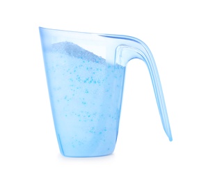 Laundry detergent in plastic measuring cup on white background