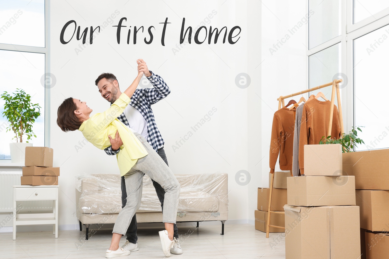 Image of First-time buyer. Happy couple dancing in their new apartment. Phrase Our First Home
