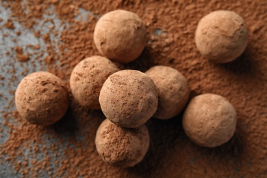 Photo of Delicious raw chocolate truffles on grey background, top view
