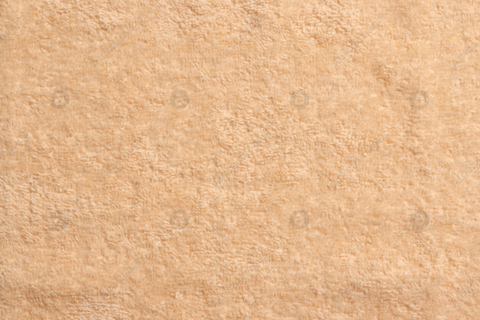 Photo of Soft pale orange towel as background, top view