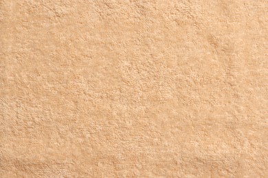 Photo of Soft pale orange towel as background, top view