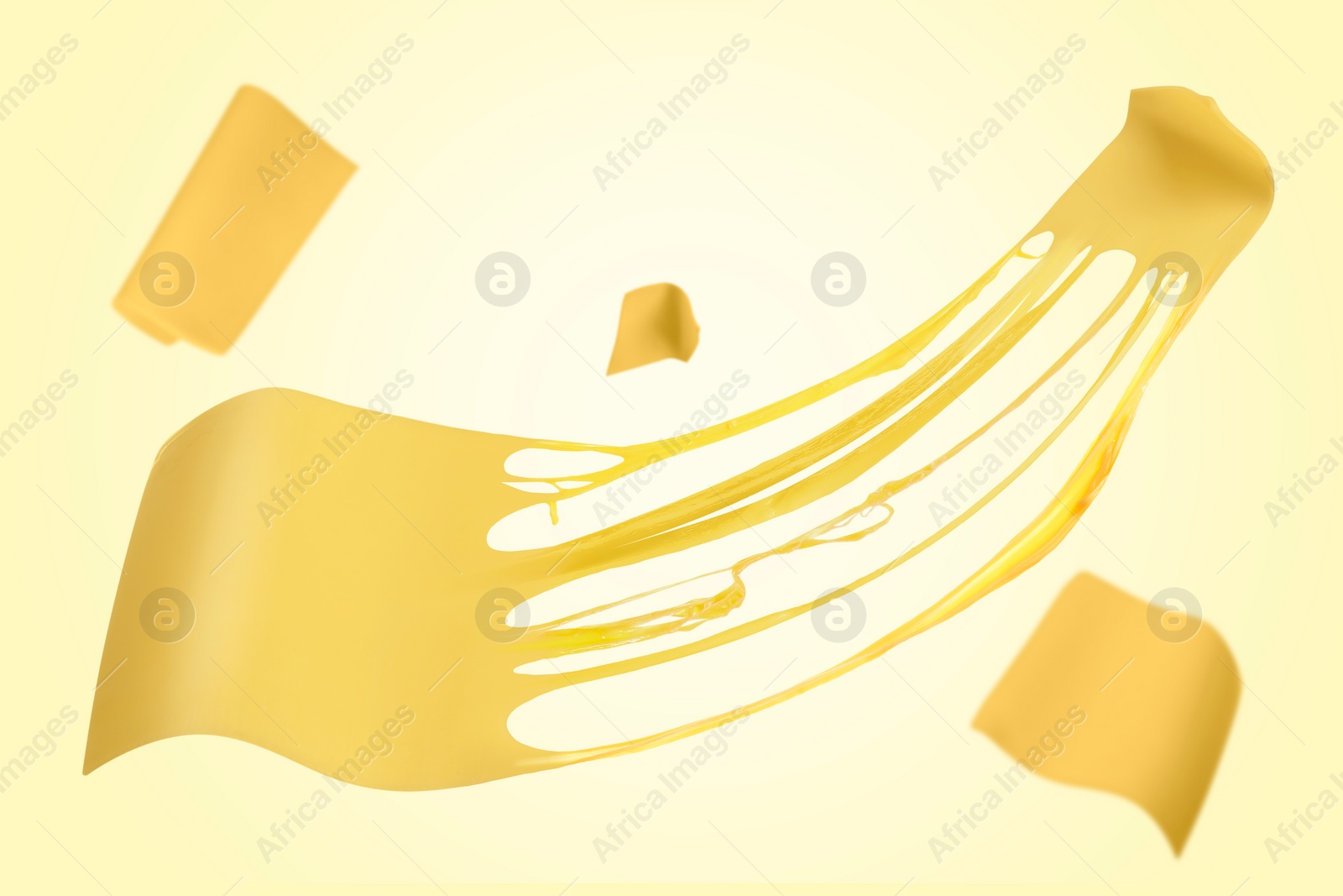 Image of Slices of cheese falling on yellow background