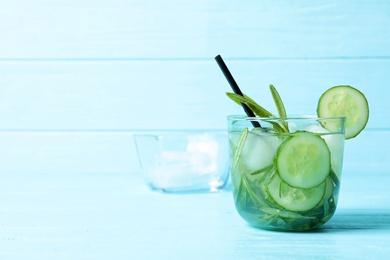 Photo of Natural lemonade with cucumber in glass on wooden table