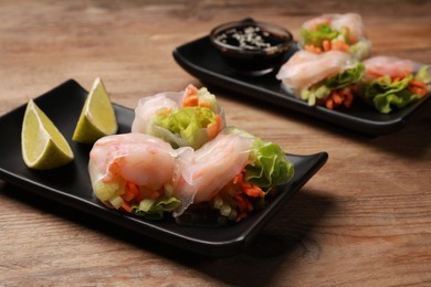 Photo of Tasty spring rolls on wooden table, closeup
