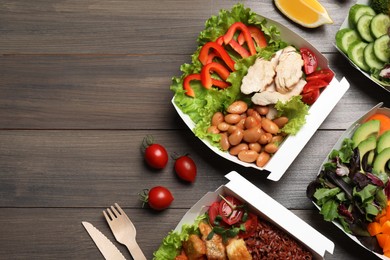 Photo of Flat lay composition with different healthy meals in takeaway boxes on wooden table. Space for text