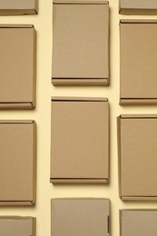 Many closed cardboard boxes on pale yellow background, flat lay