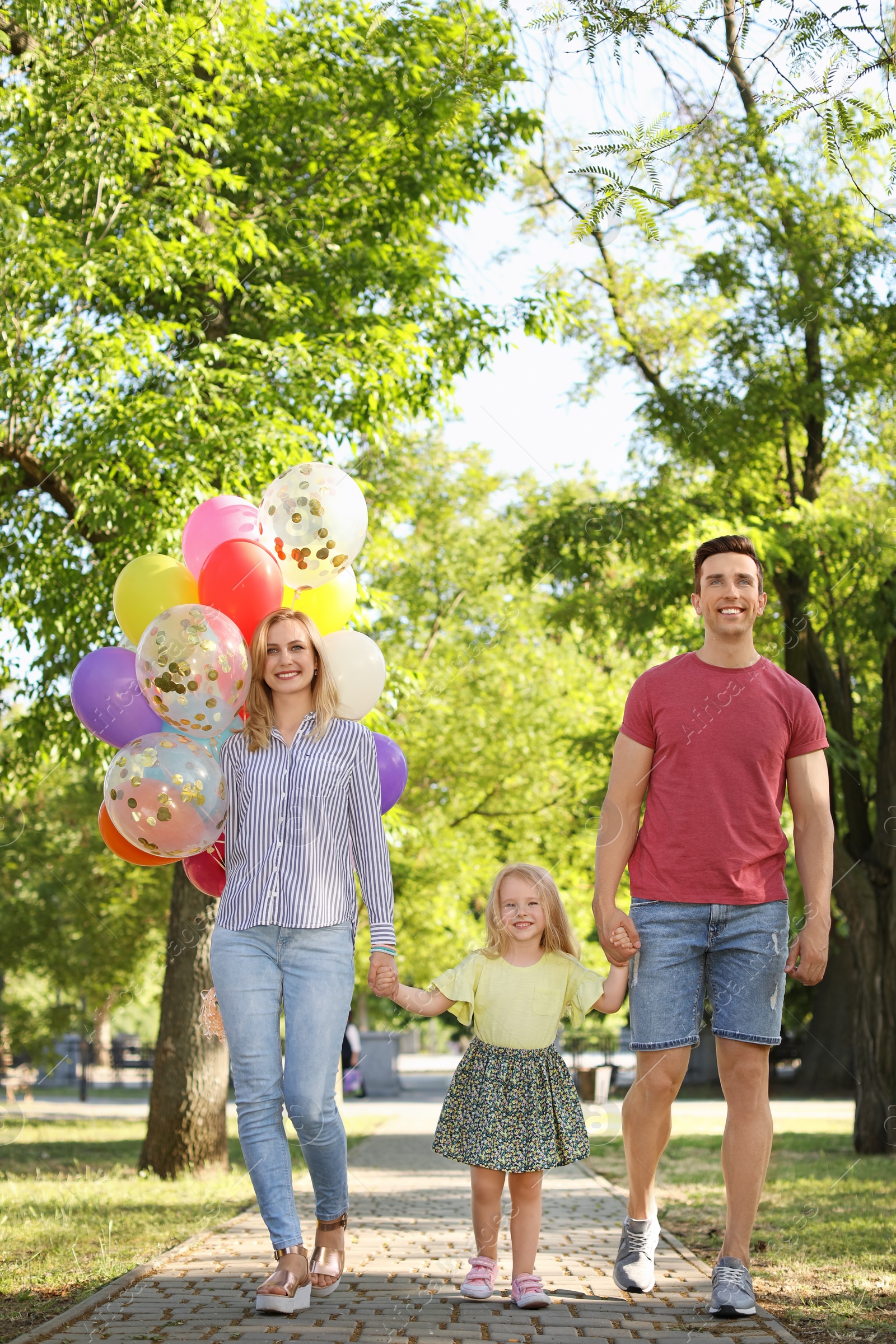 Photo of Happy family with colorful balloons outdoors on sunny day