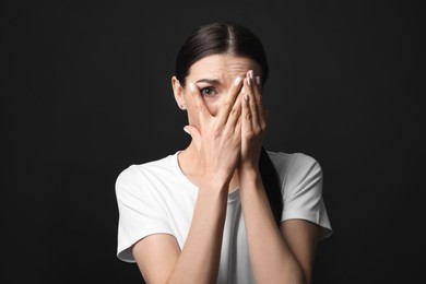 Photo of Young woman feeling fear on black background