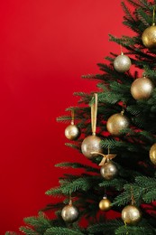 Photo of Beautifully decorated Christmas tree on red background, closeup. Space for text