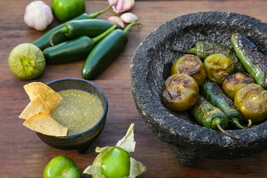 Photo of Different ingredients for cooking tasty salsa sauce on wooden table, above view