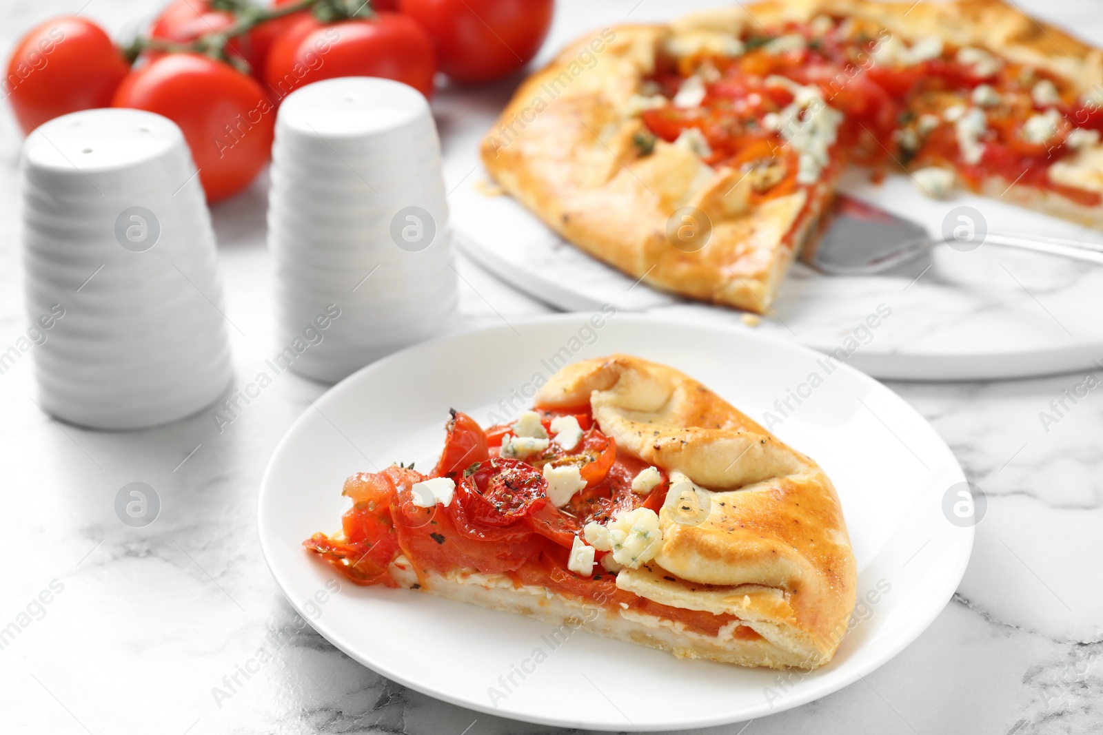 Photo of Tasty galette with tomato and cheese (Caprese galette) on white marble table, closeup