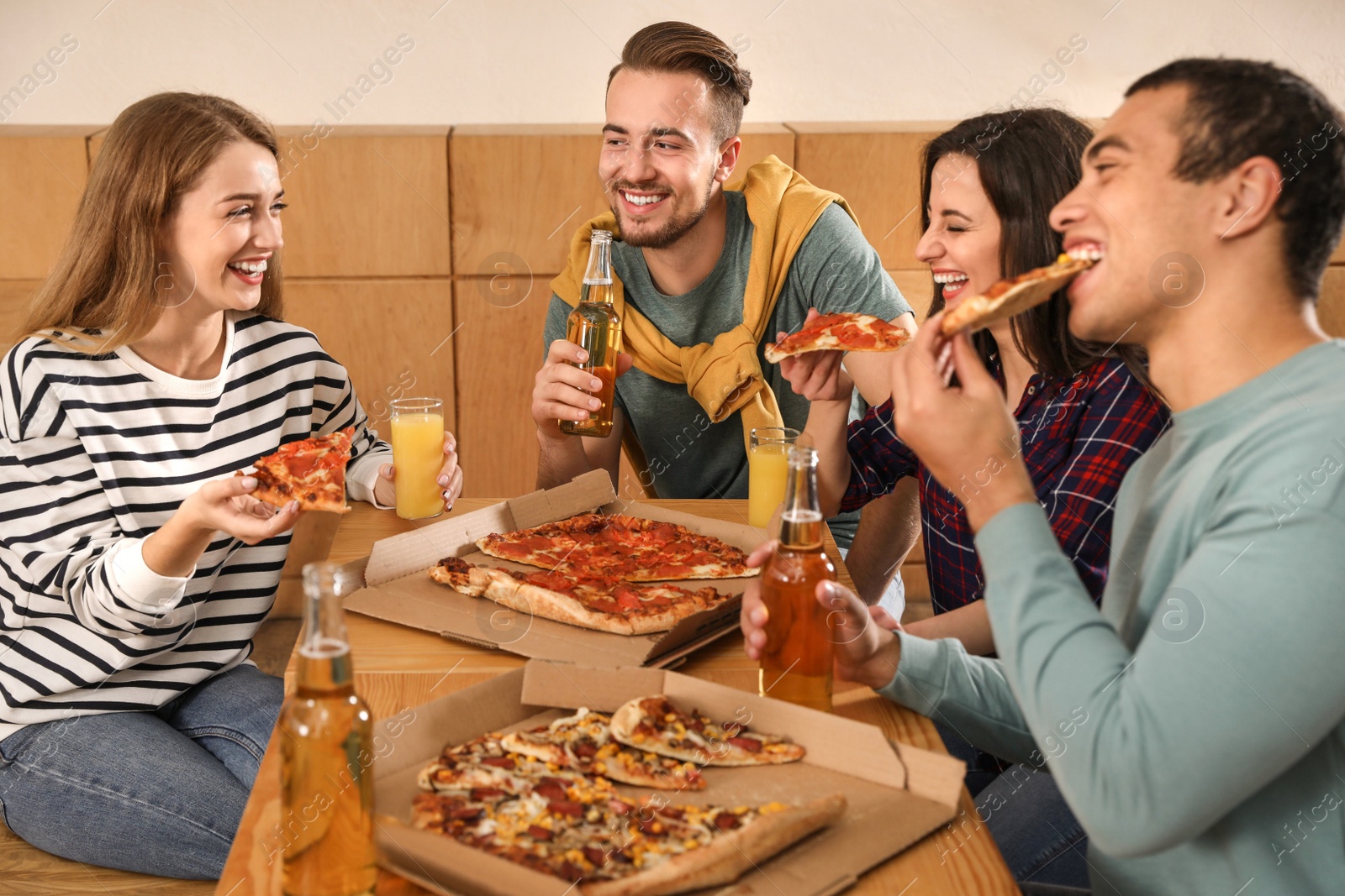 Photo of Group of friends having fun party with delicious pizza in cafe